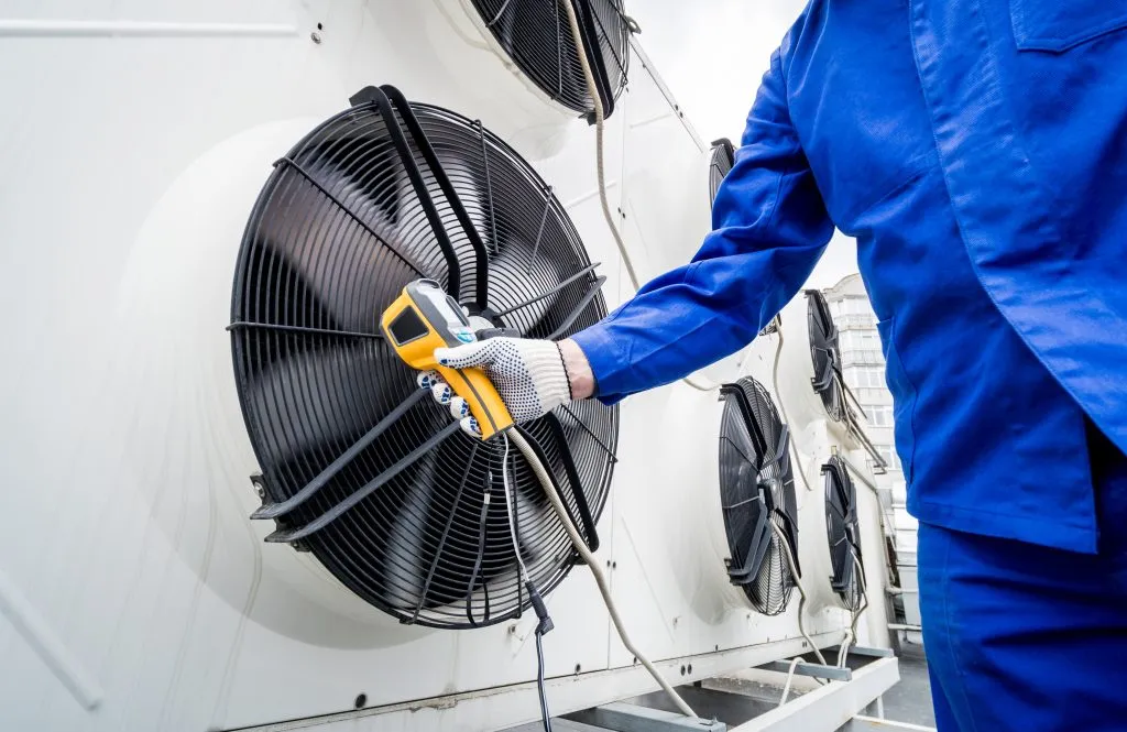 technicien contrôlant une surface d’échange avec un appareil de mesure thermique