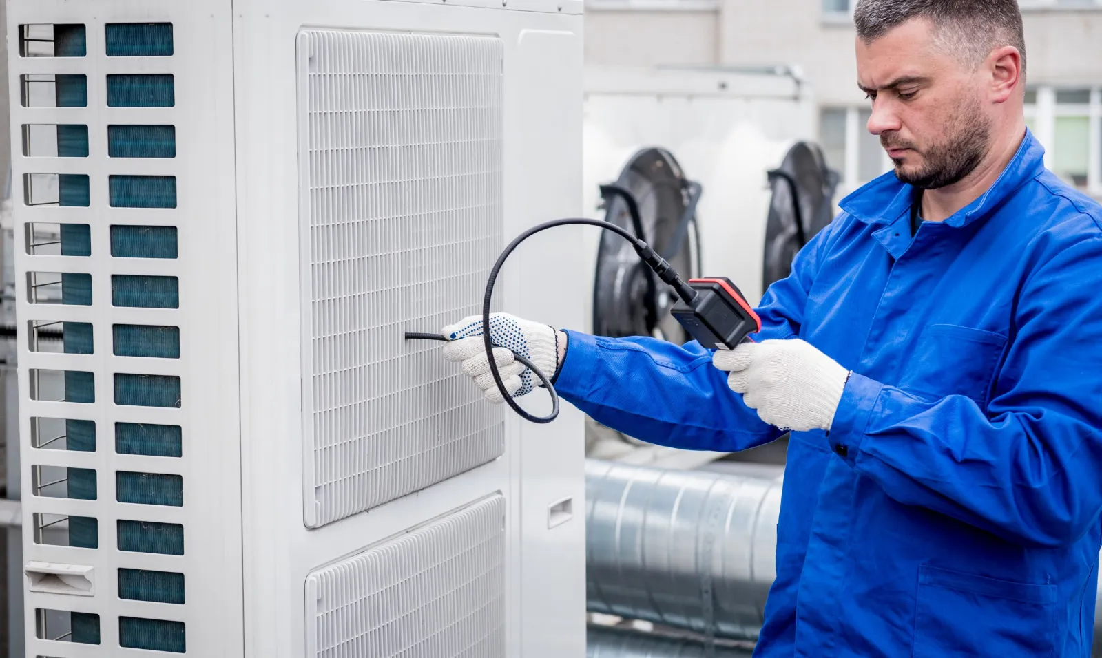 Technicien inspectant une surface d'échange de dry cooler avec une caméra