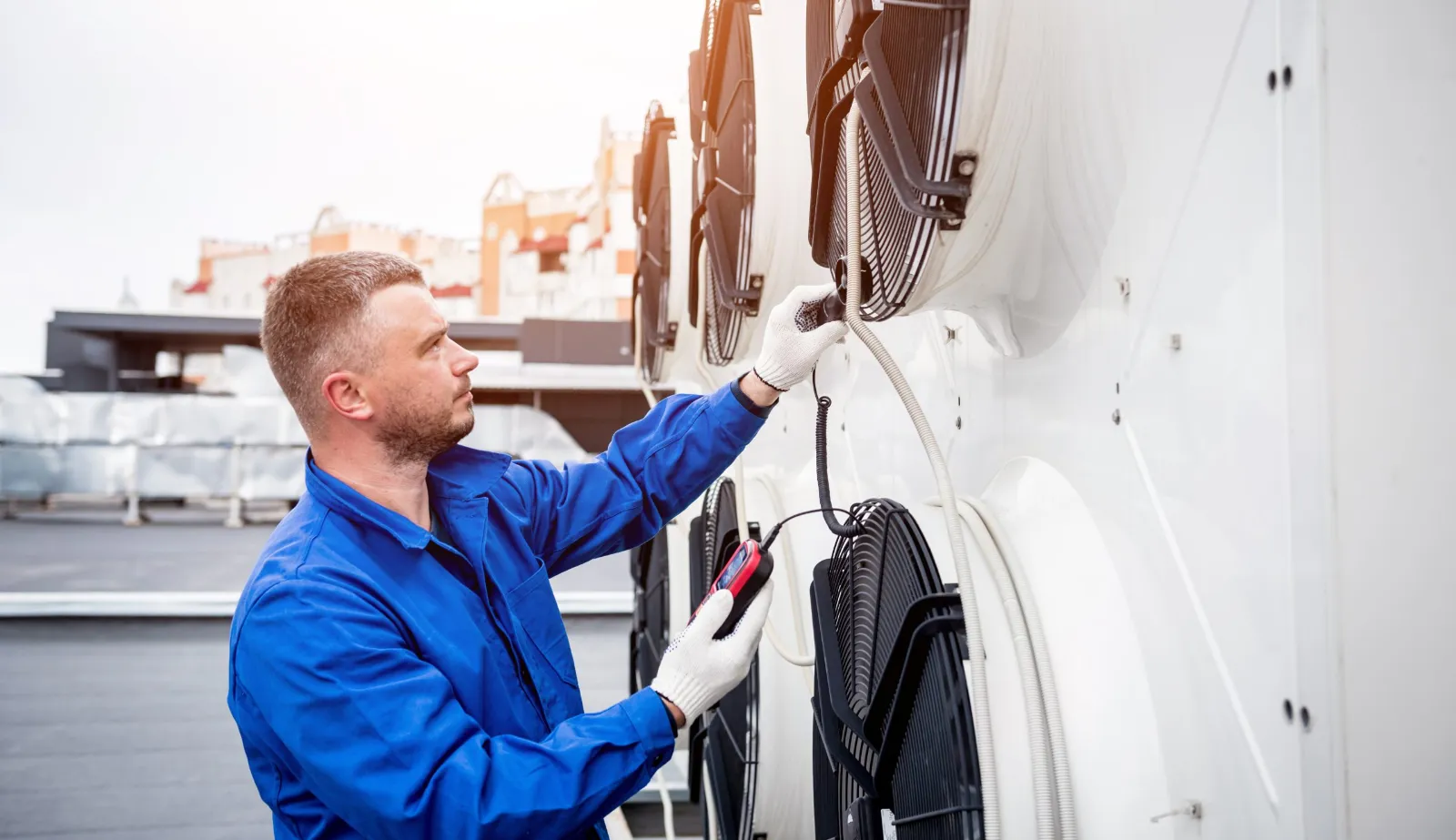 Technicien mesurant les performances d'un aéroréfrigérant à l'anémomètre